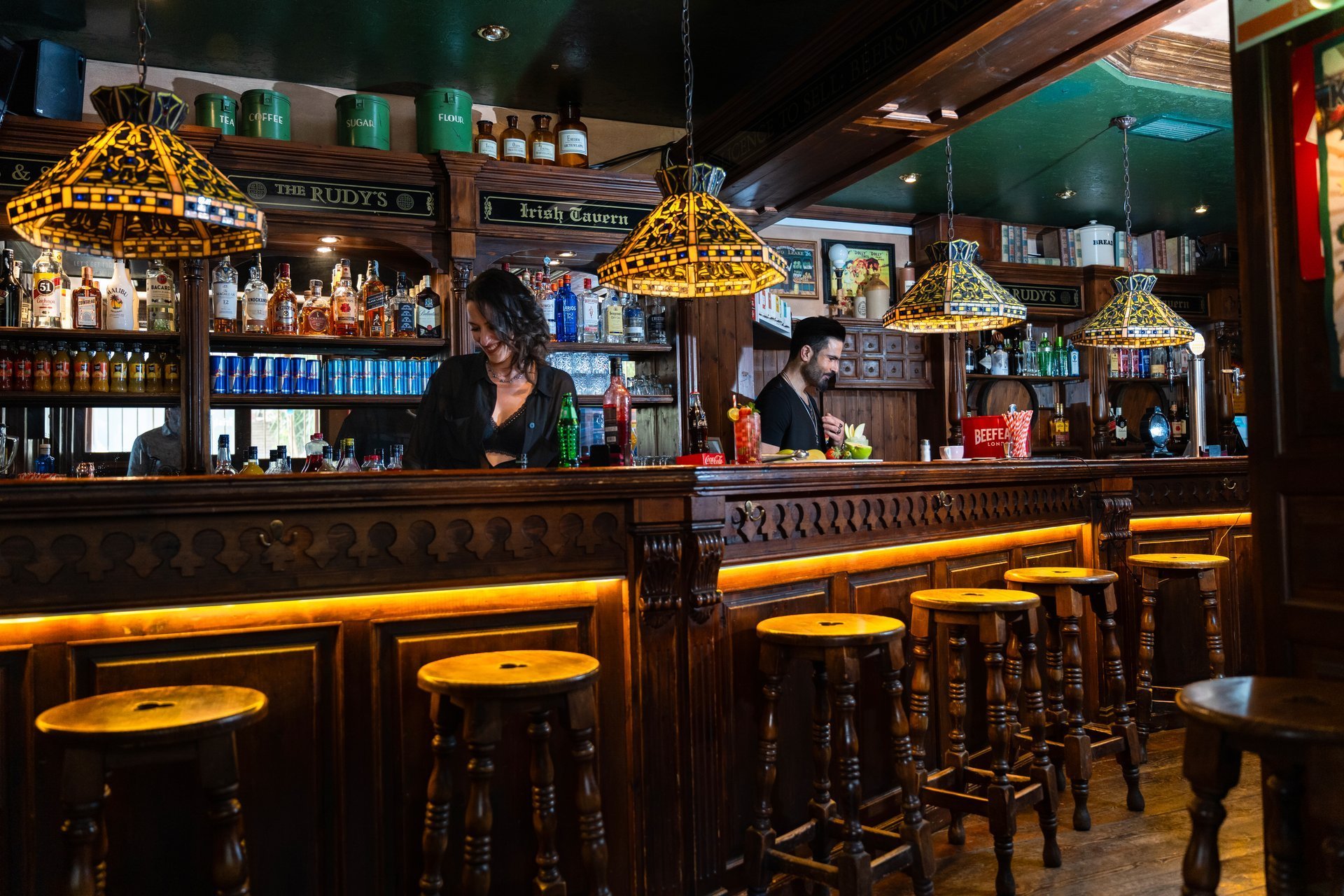 Warm rustic tavern bar interior at The Slinger House with wood counter and ambient lighting